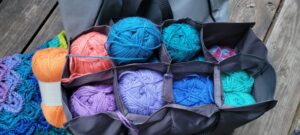 balls of yarn stuffed into the insert, some stacked two to a compartment