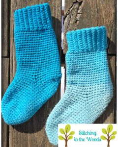 Mostly blue socks on a wood plank background with Stitching in the Woods logo in the corner